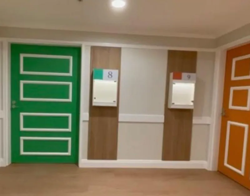 Commercial hallway with green and orange feature doors and panelled walls