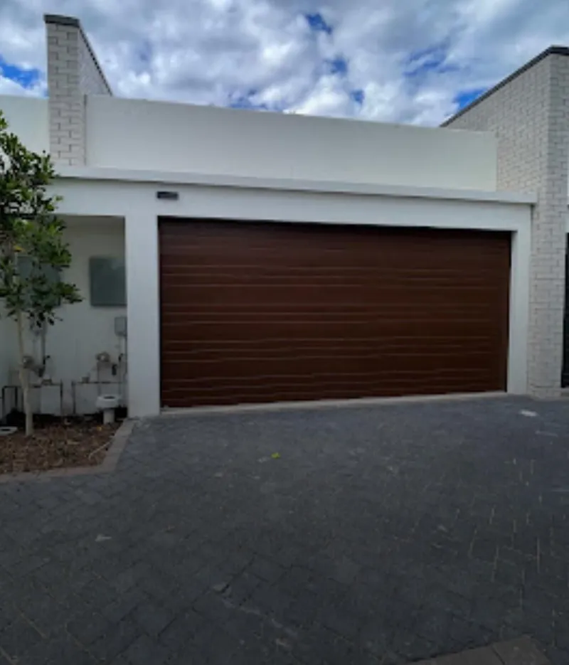 Townhouse with white render and a timber-look garage door
