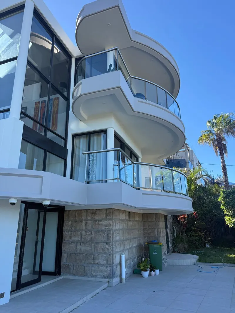 Three-storey white home with curved balconies, painted by Pae Painting