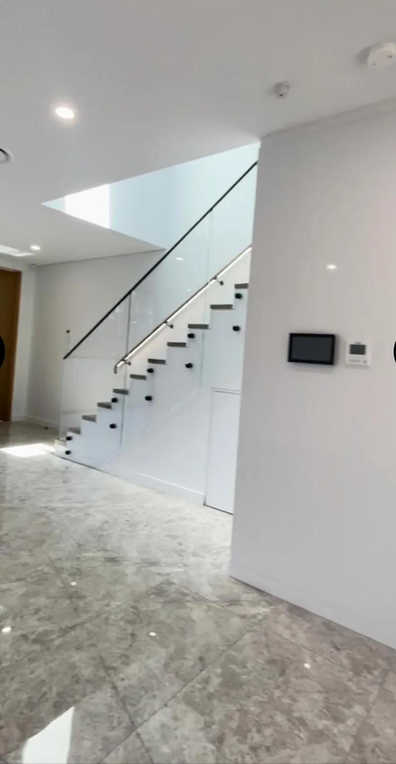 Floating staircase with glass balustrade against white walls